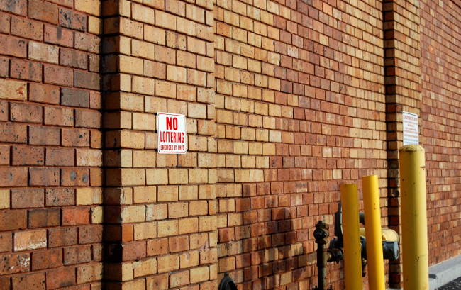 Multiple signs in an alley in Heartside warn against loitering.