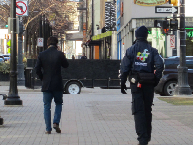 A Safety Ambassador walks down Monroe Center.